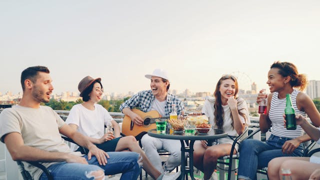 Young Adults Enjoying Rooftop Party with Guitar