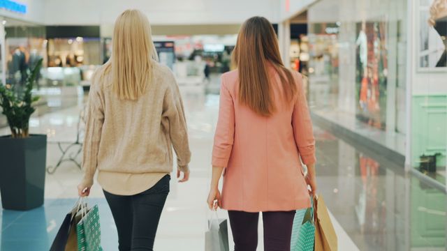 walking in a mall holding shopping bags
