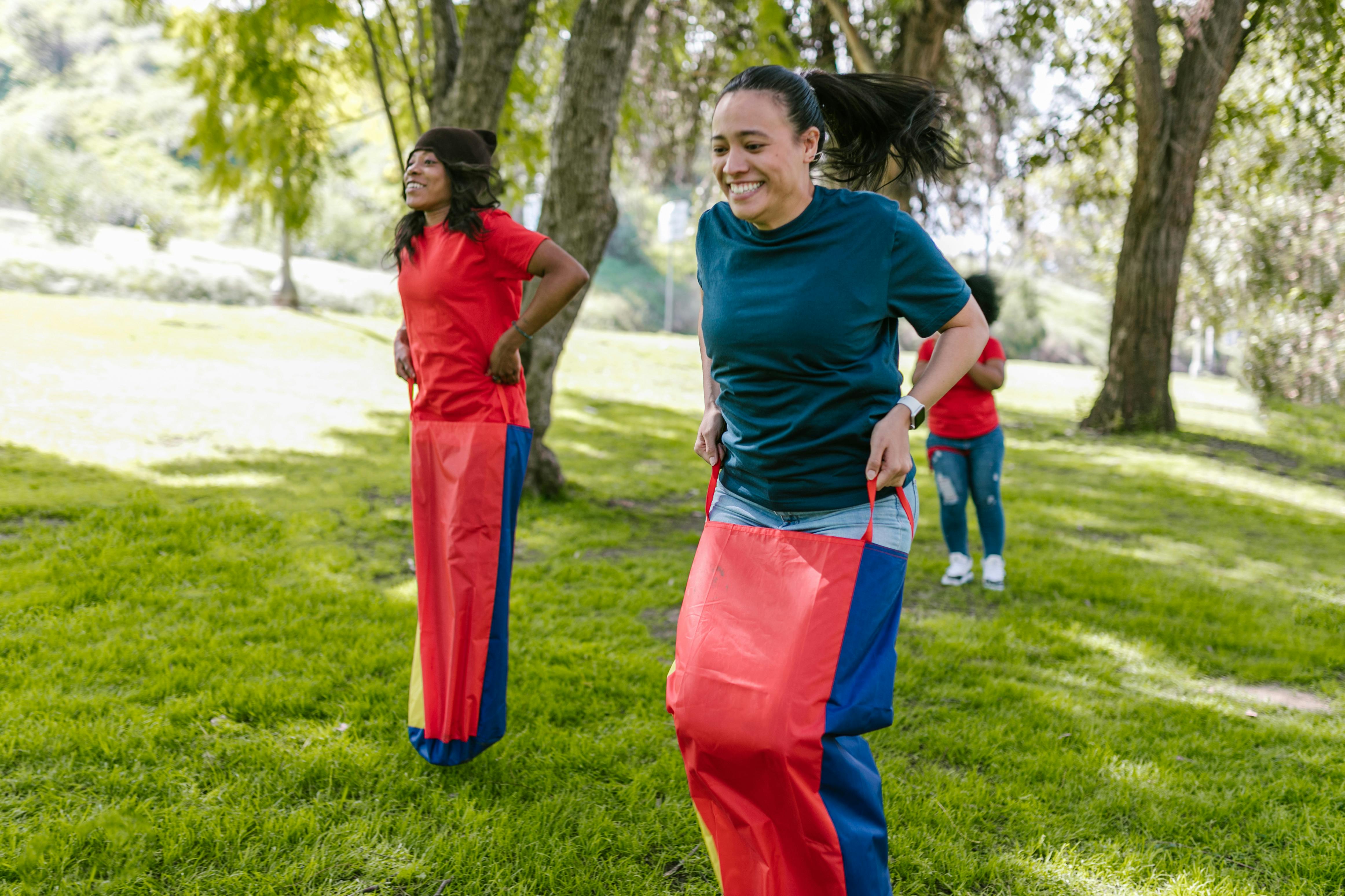 people jumping in sacks in a park